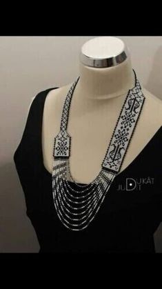 a mannequin wearing a black top and silver beaded necklace on it's neck