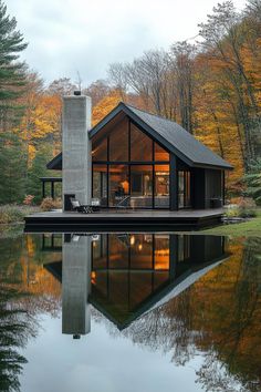 a house sitting on top of a lake surrounded by trees