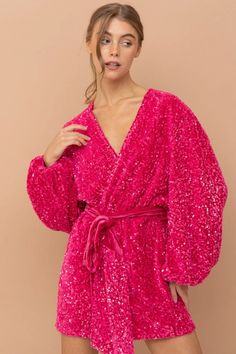 a woman wearing a pink robe with sequins on it