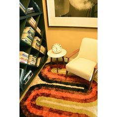 a room with a chair, table and bookshelf