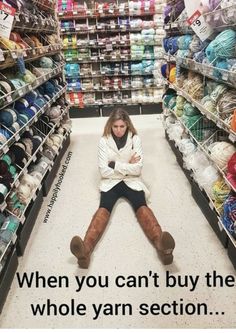 a woman sitting on the floor in a store with her arms crossed and legs crossed