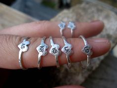 a person's hand holding five rings with numbers on them