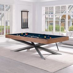 a pool table in the middle of a living room with white walls and flooring