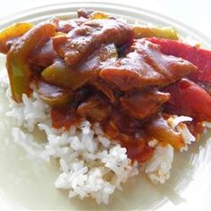 a white plate topped with rice and meat