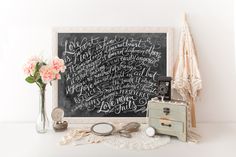 a chalkboard with writing on it next to some flowers and other things in front of it