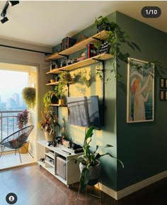 a living room filled with lots of plants next to a sliding glass door that opens onto a balcony