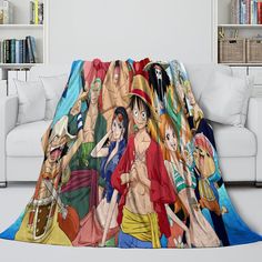 one piece anime blanket with all the main characters and their names printed on it, in front of a white couch