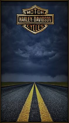 an empty road with the words harley davidson cycle on it's side under a cloudy sky