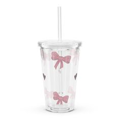 a clear cup with pink bows on the side and a straw sticking out of it