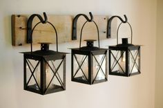 three black lanterns are hanging on the wall