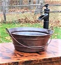 an old fashioned water fountain sitting on top of a wooden table