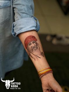 a man's arm with a tattoo on it that has an image of a bearded man