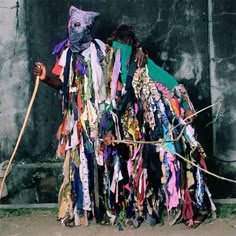 a man standing next to a pile of scarves