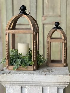 two small wooden lanterns with candles on top