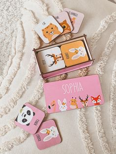 four animal themed coasters in a pink box on a white blanket with personalized tags