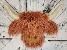 a stuffed animal that looks like a yak is hanging on a wall with wood planks