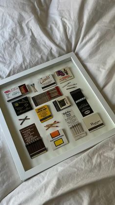 a white frame with many different types of books in it on top of a bed