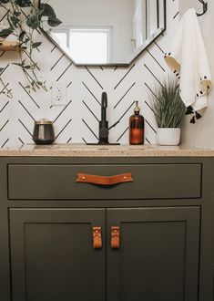 a bathroom vanity with a mirror, soap dispenser and plants on it