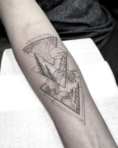 a man's arm with a triangle and mountains tattoo on the left inner forearm