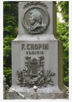 a monument with a plaque on it that says f r chopin and is in front of some trees