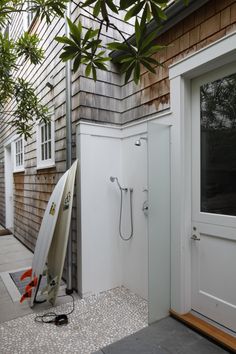 a surfboard leaning against the side of a house