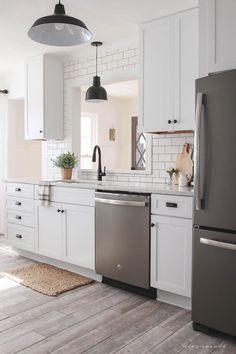 a kitchen with white cabinets and stainless steel appliance on the counter, along with a gray dishwasher