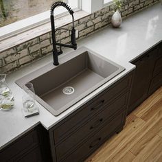 a kitchen sink sitting on top of a counter next to a faucet and window