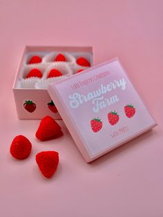 strawberries in a box on a pink surface