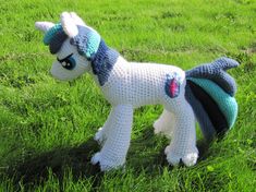 a crocheted pony is standing in the grass