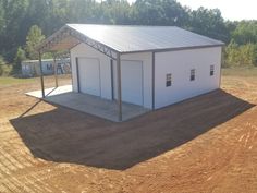 a white building sitting on top of a dirt field