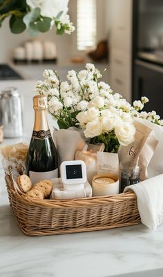 a wicker basket filled with champagne, cookies and other items on a kitchen counter