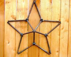 a metal star on a wooden fence with nails sticking out of it's center