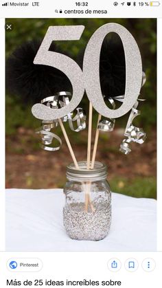 there is a mason jar with some silver numbers on it and toothpicks sticking out of the top