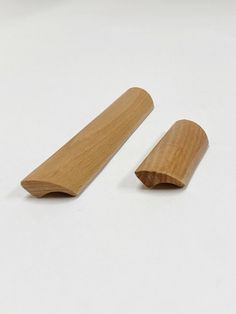 two pieces of wood sitting next to each other on a white surface with space for text