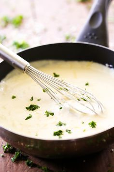 a pan filled with soup and whisk on top of it