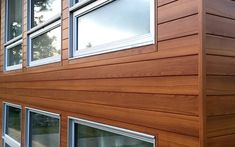 the side of a house with windows and wood sidings on it's sides