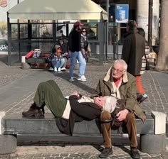 an older man is sitting on a bench with his feet up and one foot in the air