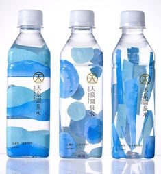 three water bottles with blue and white designs on them