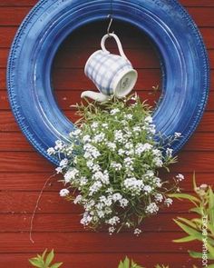 a potted plant sitting on top of a wooden table next to a blue tire