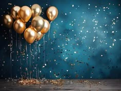 gold balloons floating in the air with confetti and streamers