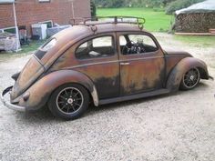 an old rusted car parked in front of a brick building