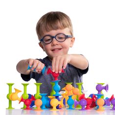 a young boy playing with colorful plastic toys