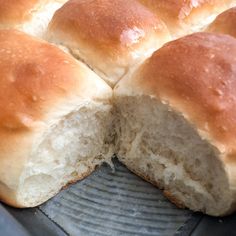 a loaf of bread cut in half on top of a metal pan with one slice taken out