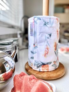 a kitchen counter with a tea pot and watermelon slice on the plate next to it