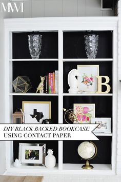 a black and white bookcase with pictures, vases and other items on it