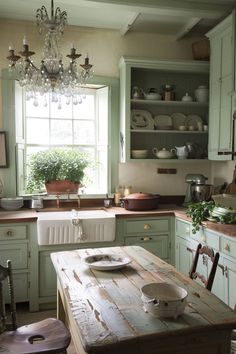 a kitchen with green cabinets and a wooden table