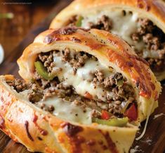 some meat and cheese stuffed bread rolls on a cutting board