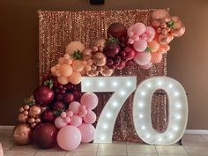 a large balloon arch with the number seventy in front of it and balloons all around it