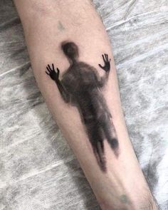 a man's arm with a black and grey silhouette of a person on it