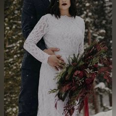 a bride and groom standing in the snow